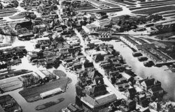 Luchtfoto van Broek op Langedijk met rechts de Broeker Veiling en geheel rechtsonder de J.D. van Arkelschool. De nieuwe kleuterschool staat er reeds, dus is de foto van ná 1963